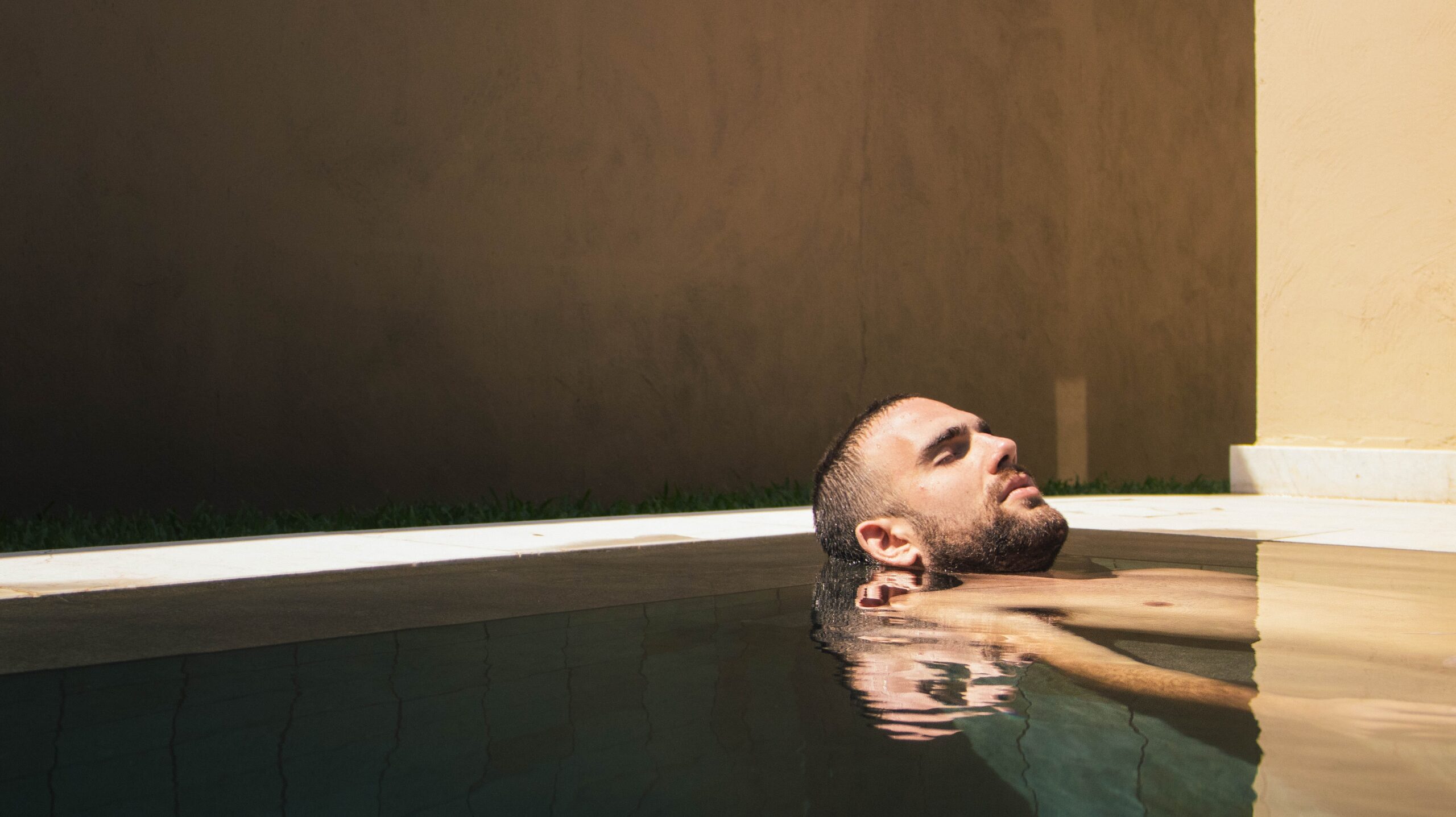 一名男子在游泳池中静静地躺着，以放松身心