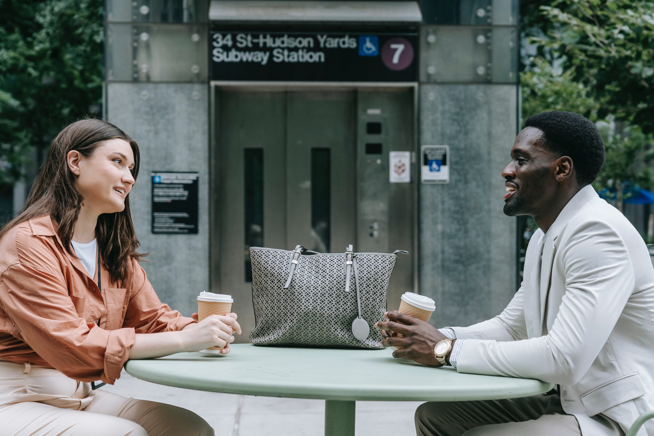 Un homme et une femme prennent un café devant un café de New York.