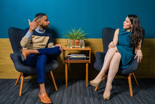 Dos personas elegantemente vestidas participan activamente en una conversación